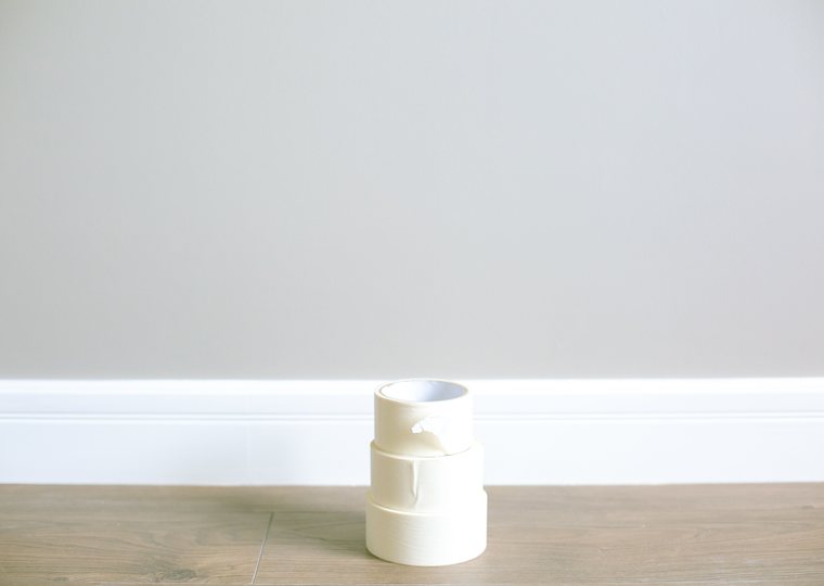 Rollen afplaktape naast een witte plint