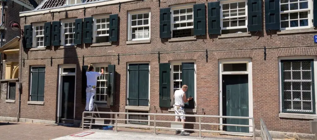 Schilders aan het werk aan een rij bakstenen woningen