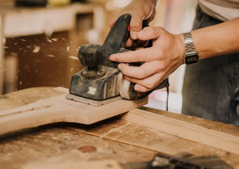 Houtwerk wordt machinaal geschuurd voor het schilderen