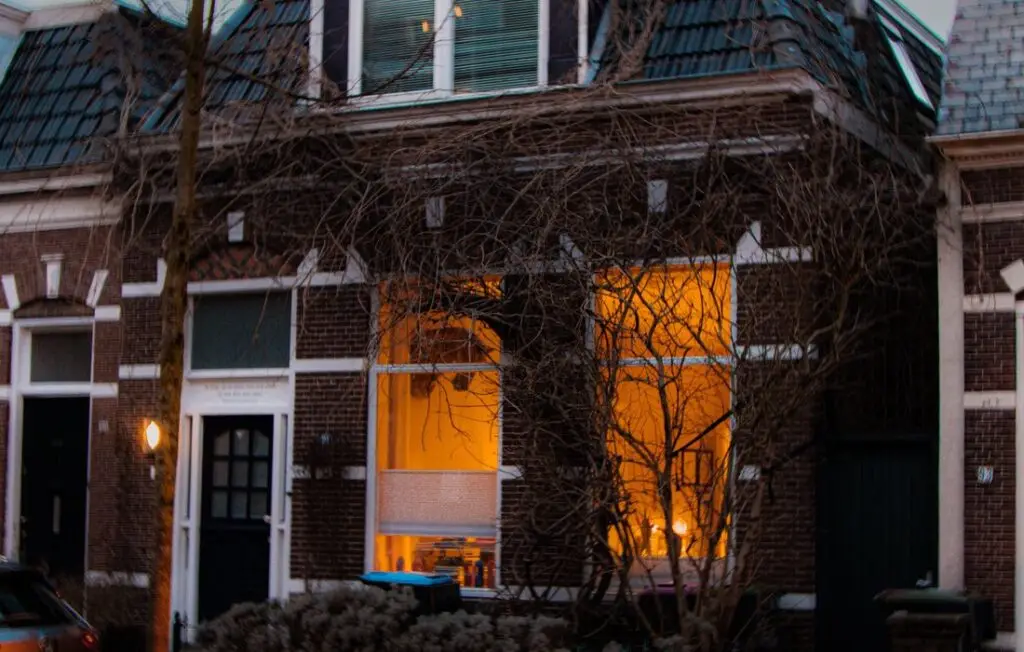 Woonhuis met verlichte erker in de avond